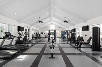 A spacious gym with treadmills, elliptical machines, and other exercise equipment.